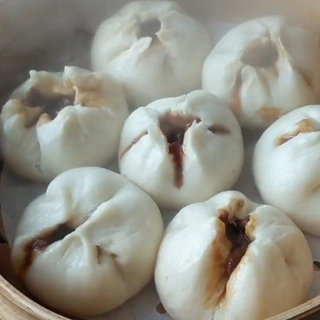 Bánh bao xá xíu có lớp vỏ xốp mềm, trắng mướt, bánh xé ra có mùi thơm nhẹ cùng vị bùi ngọt hấp dẫn. Bên trong là phần nhân thịt và sốt xá xíu đậm đà.